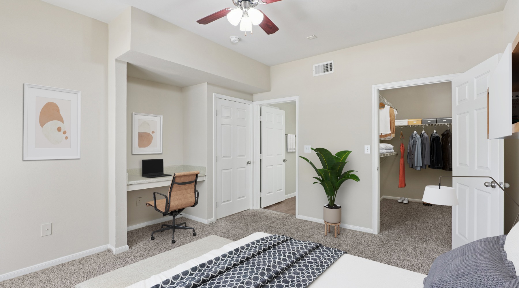bedroom with bed plant desk and ceiling fan at Apartments in Humble,TX
